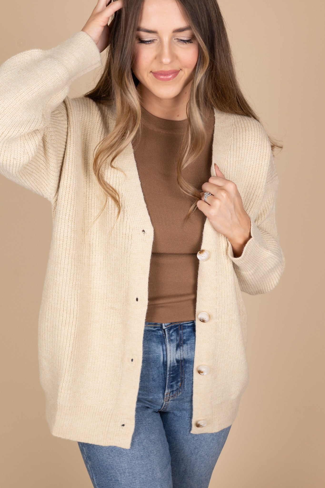 Everyday Oversized Cardigan in taupe color with cream and brown tortoise buttons. Oversizes comfy fit. Paired with brown high neck tank and medium wash jeans.