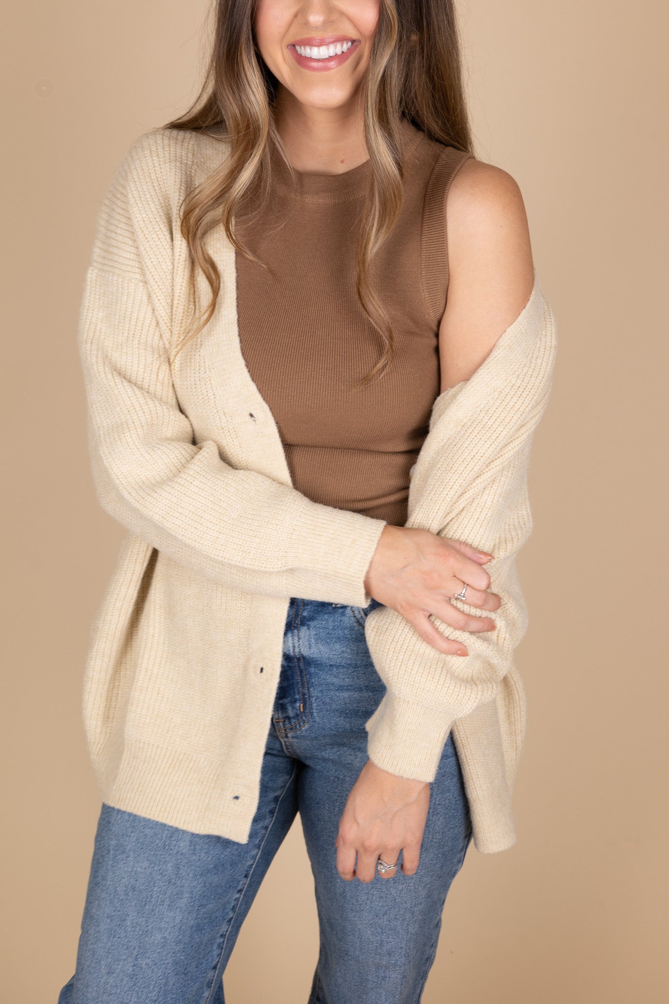 Everyday Oversized Cardigan in taupe color with cream and brown tortoise buttons. Oversizes comfy fit. Paired with brown high neck tank and medium wash jeans.