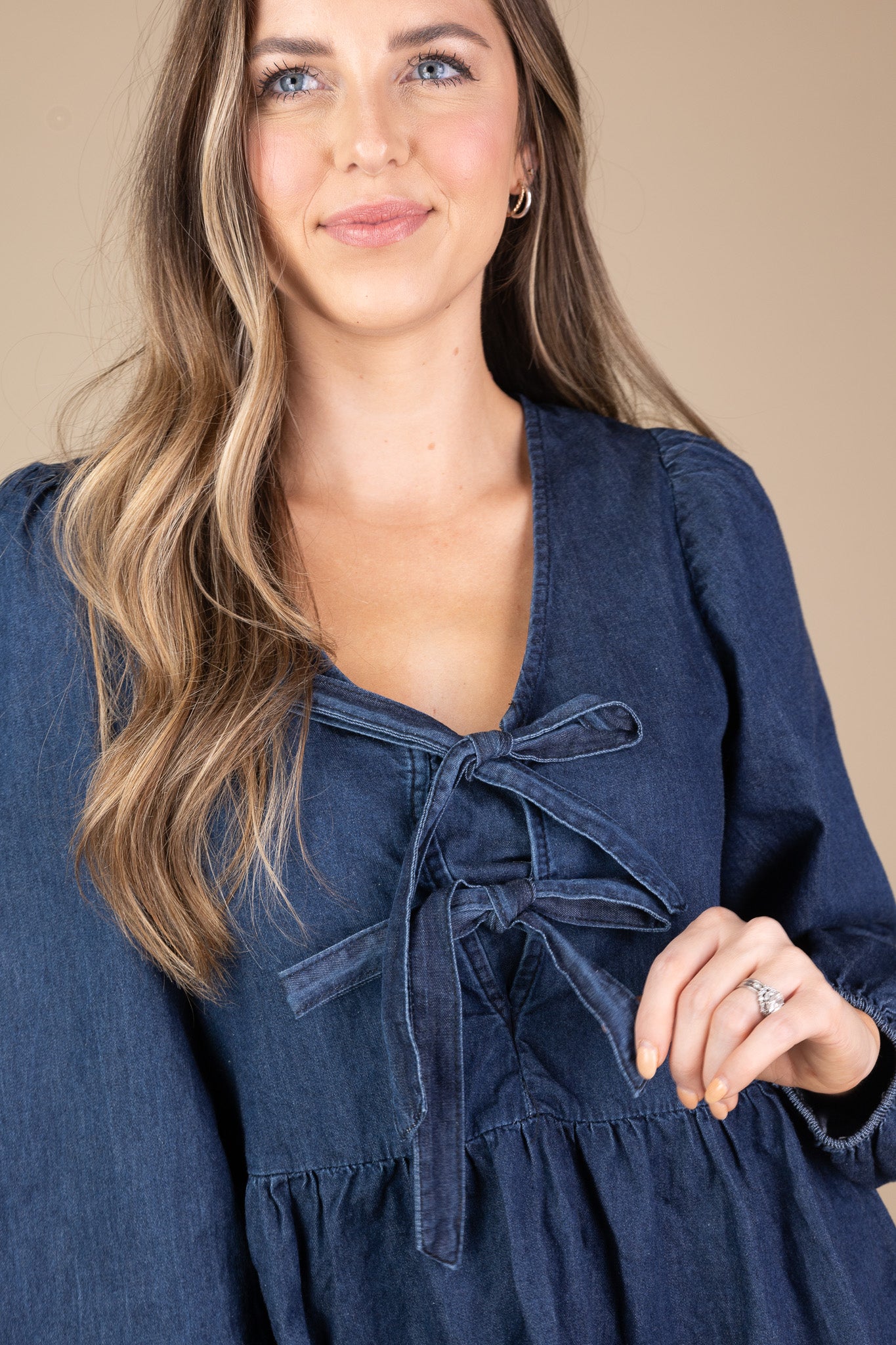 bow detail of Raelyn Bow Blouse in medium to dark wash with peplum design and two adjustable bow details, perfect for elegant styling.