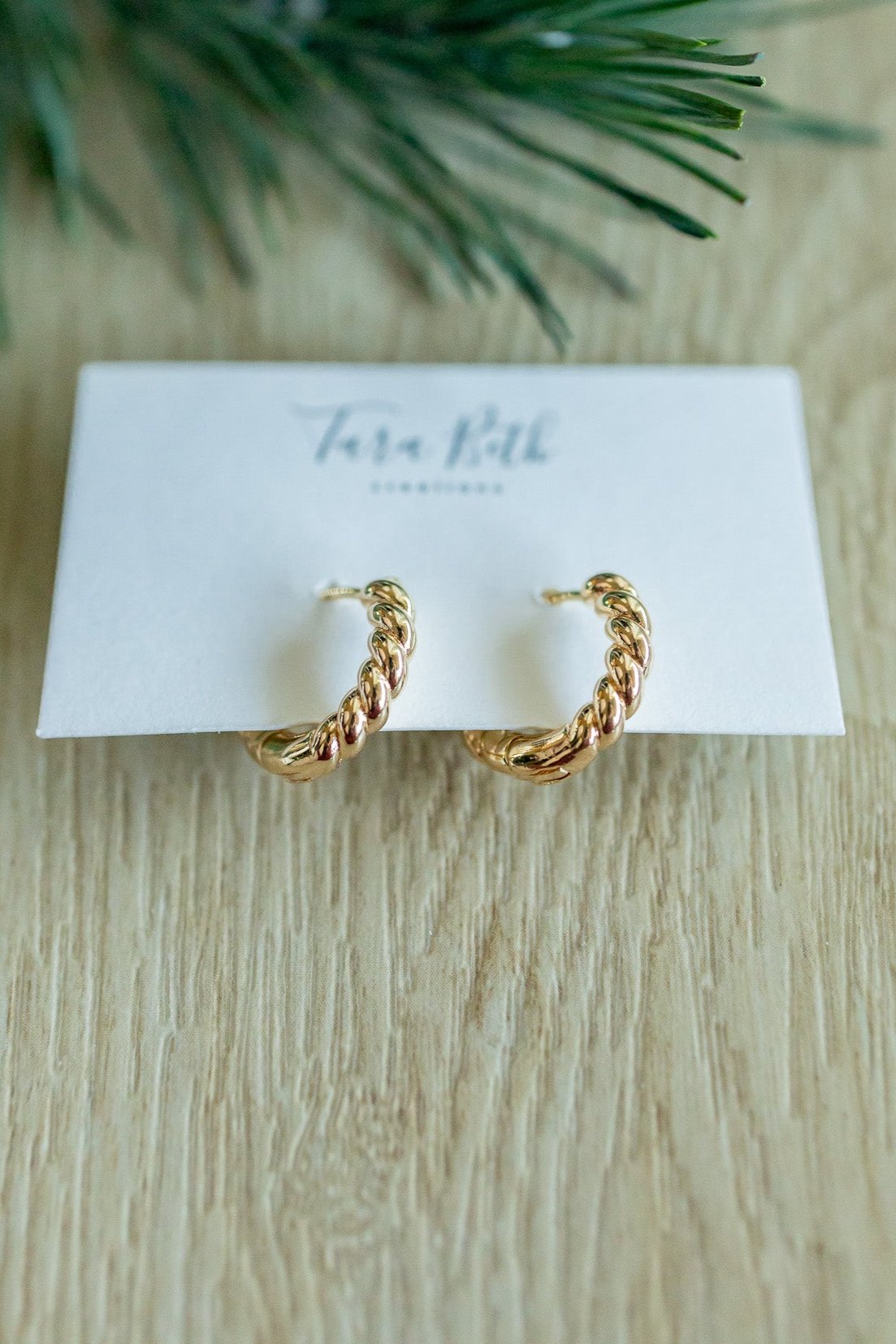 close up view of “Gold Twisted Hoops – elegant and lightweight hoop earrings with a modern twisted design for a timeless look.”