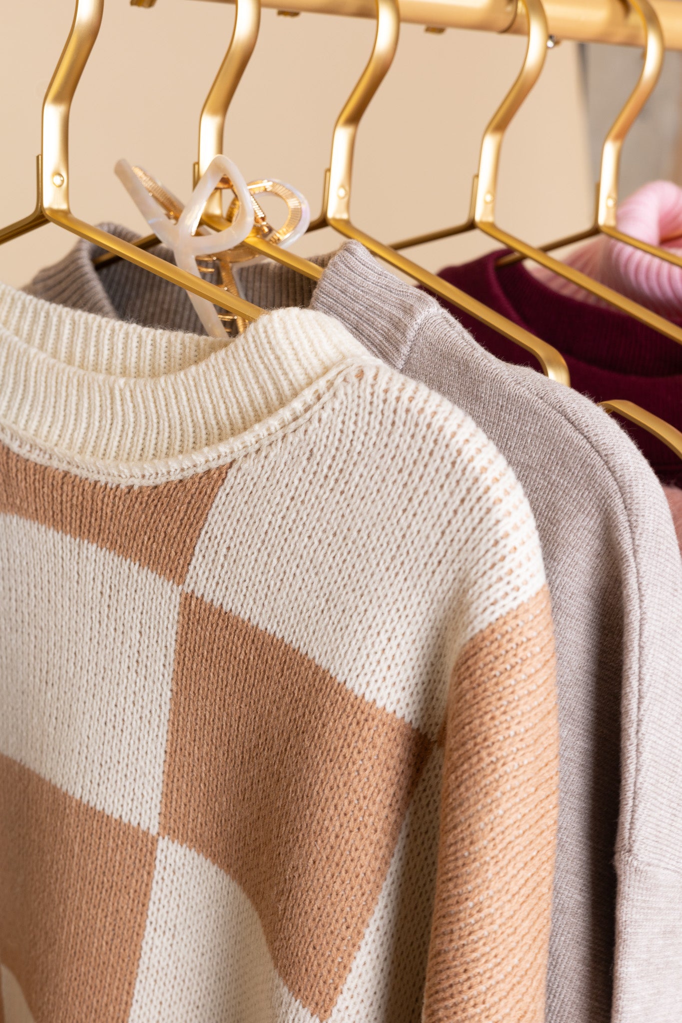 hangered view of “Cozy Checkered Crewneck Sweater – a soft knit sweater with a stylish checkered pattern and relaxed fit for effortless comfort.”