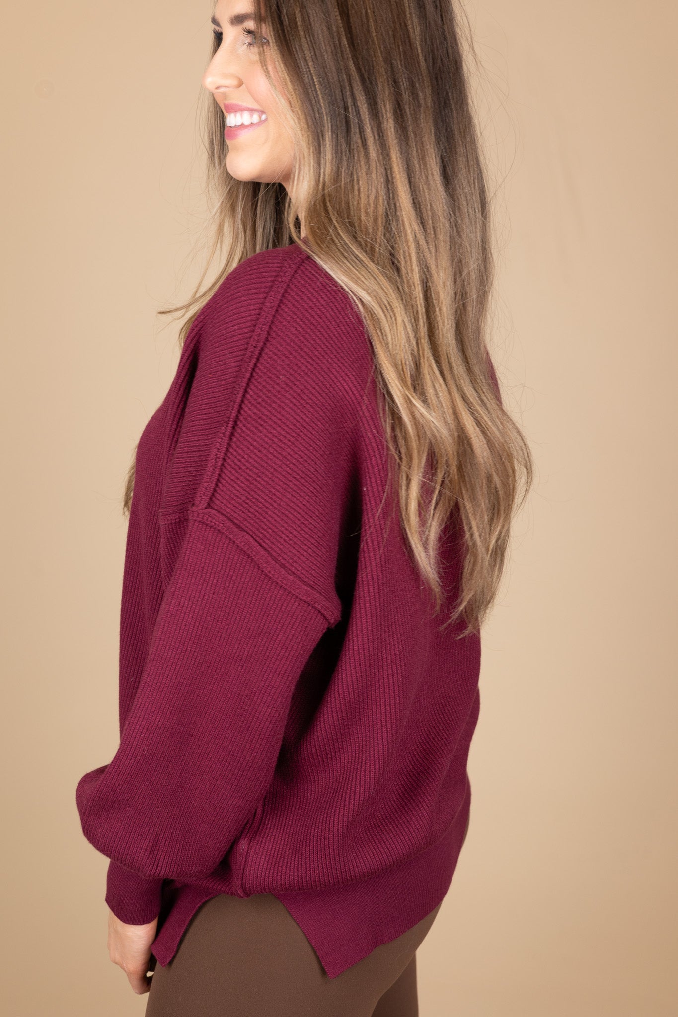 side view of “Cozy Crewneck Sweater in Wine Red – a soft, oversized knit sweater with a classic crewneck design for effortless style.”