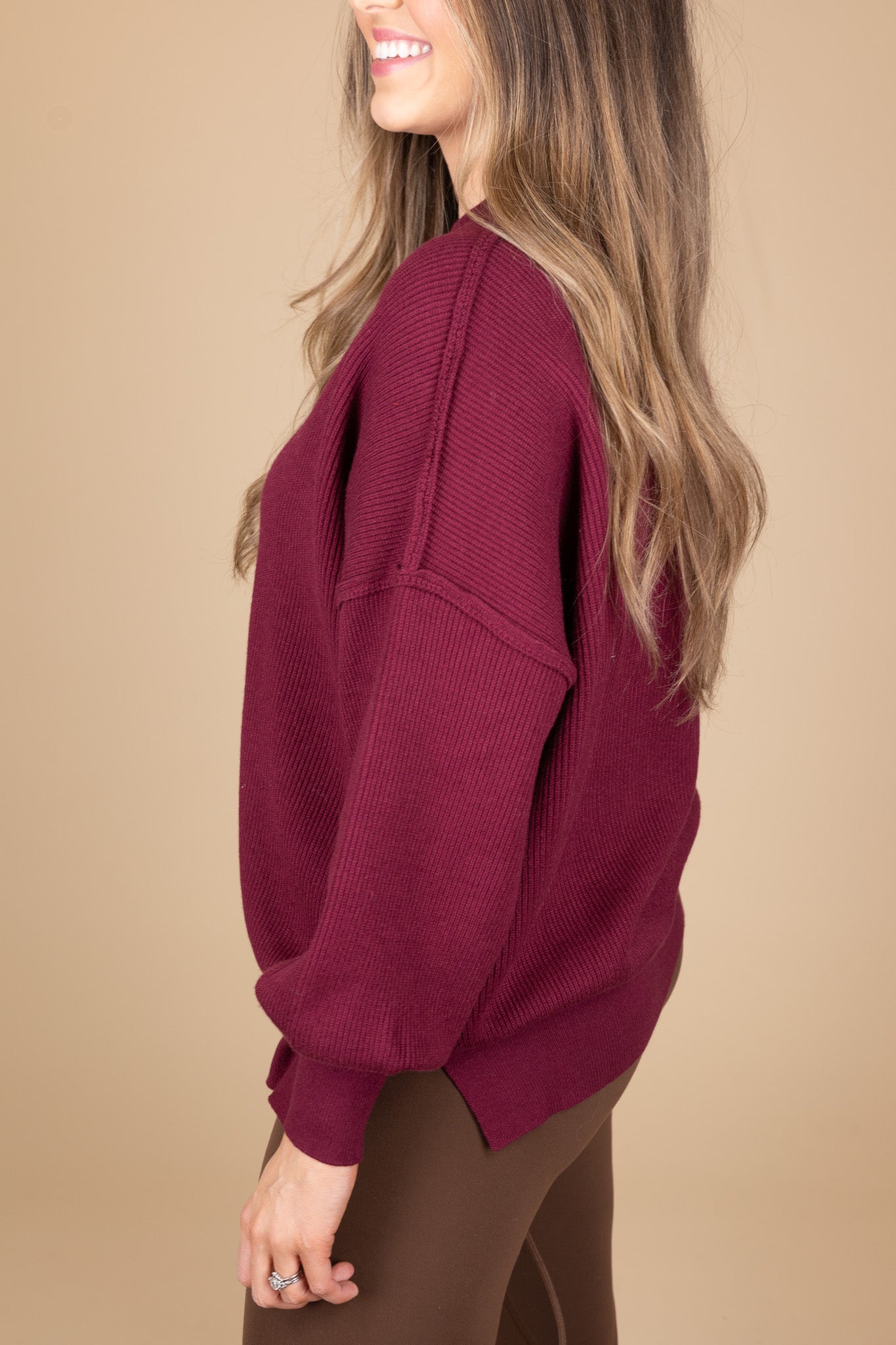 side view of “Cozy Crewneck Sweater in Wine Red – a soft, oversized knit sweater with a classic crewneck design for effortless style.”