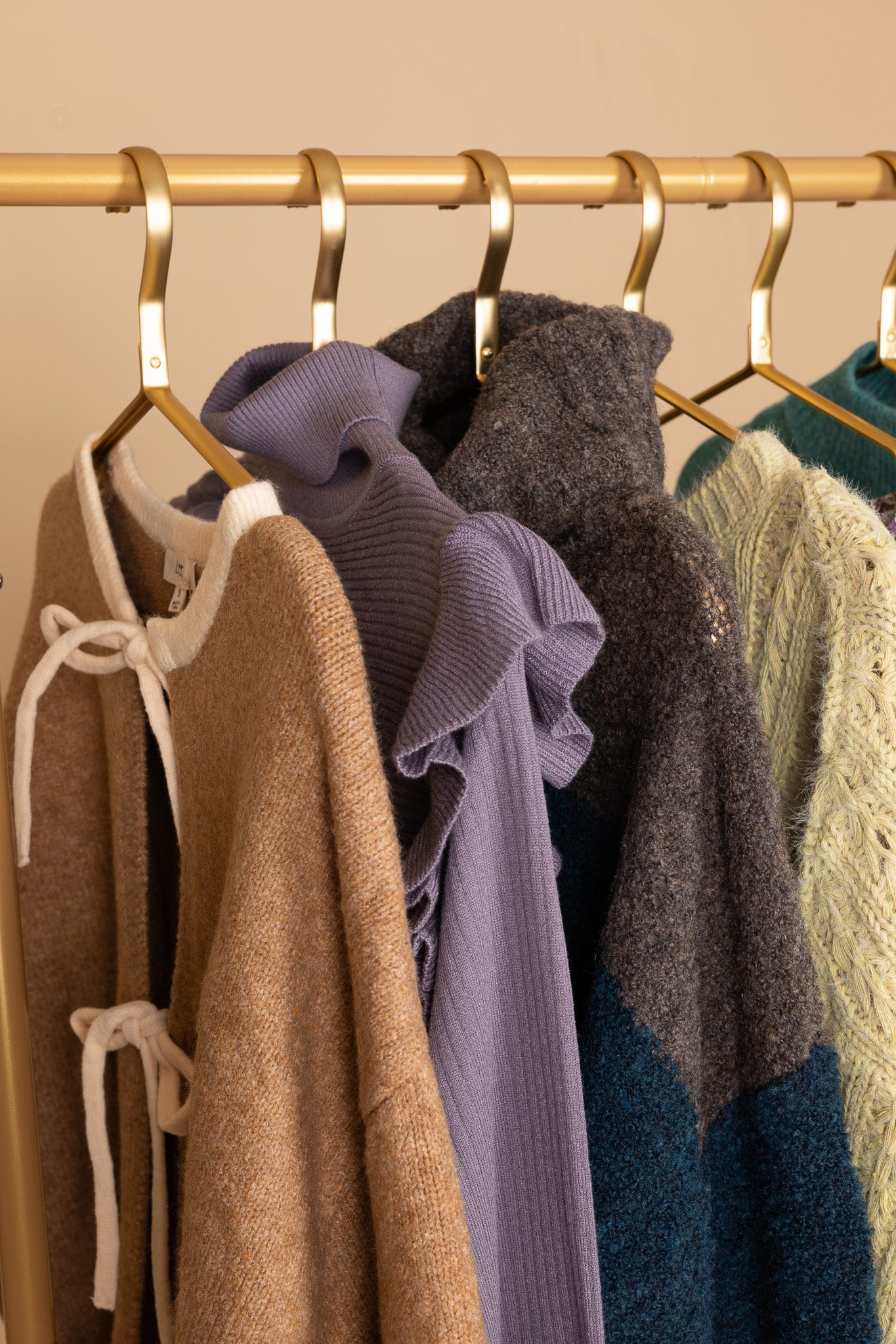 hangered view of “Daphne Flutter Sleeve Sweater – a soft ribbed knit turtleneck sweater with delicate flutter sleeve detailing.”