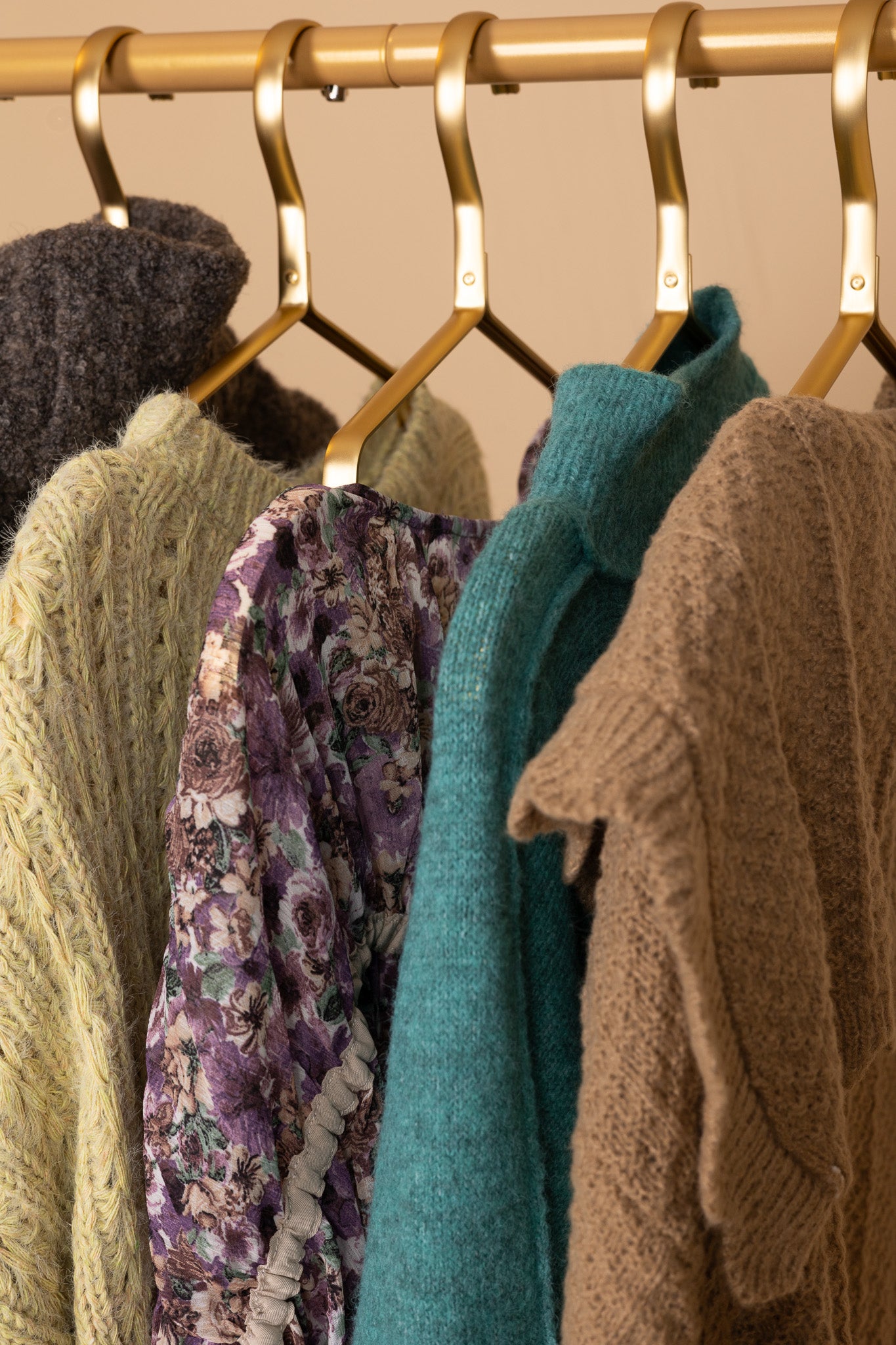 hangered view of “Aster Blouse – a chic and feminine puff sleeve top with a soft shimmer and elegant tie-back detail.”