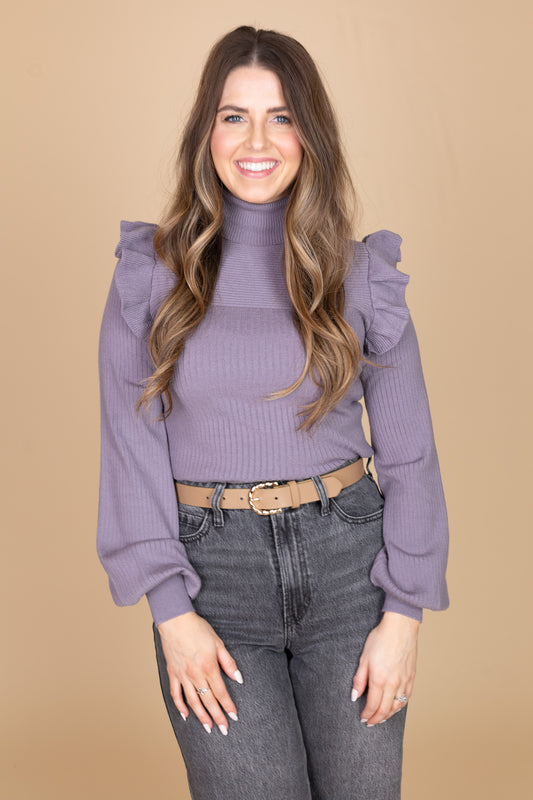 “Daphne Flutter Sleeve Sweater – a soft ribbed knit turtleneck sweater with delicate flutter sleeve detailing.”