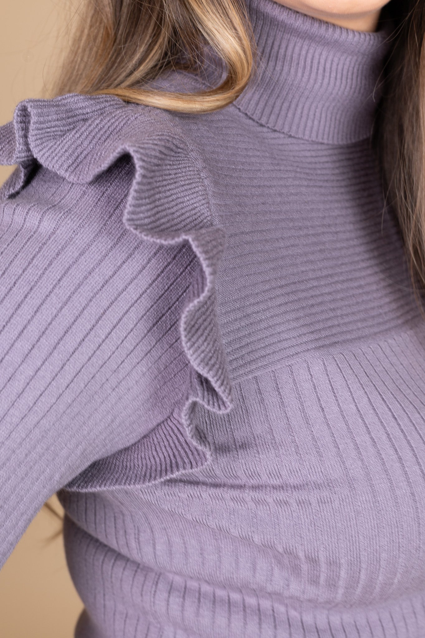 shoulder ruffle detail view of “Daphne Flutter Sleeve Sweater – a soft ribbed knit turtleneck sweater with delicate flutter sleeve detailing.”