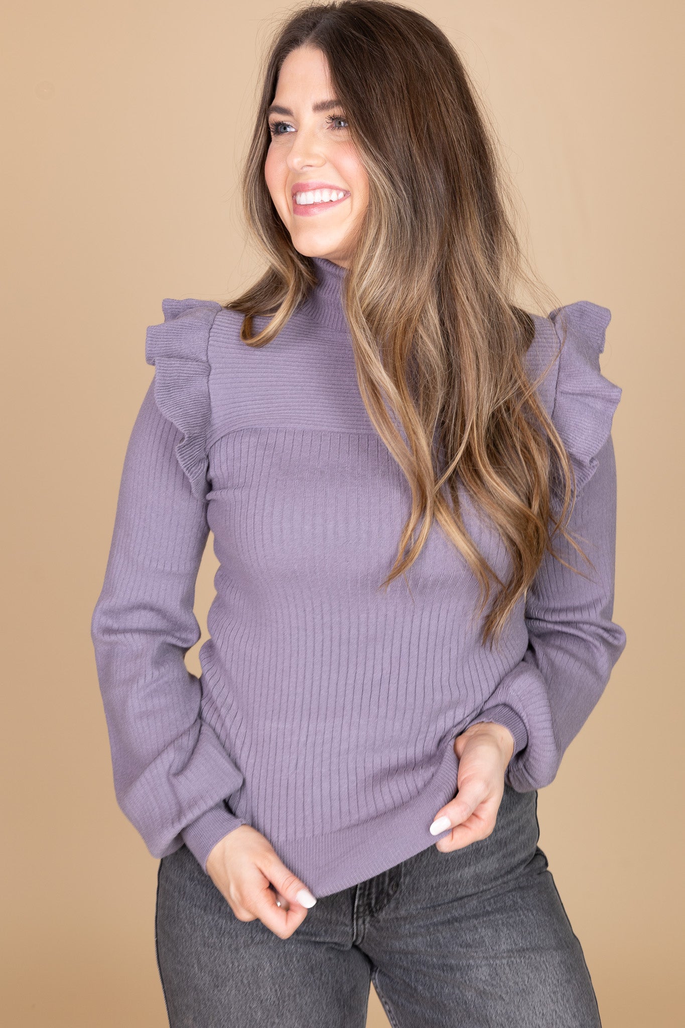 hem view of “Daphne Flutter Sleeve Sweater – a soft ribbed knit turtleneck sweater with delicate flutter sleeve detailing.”