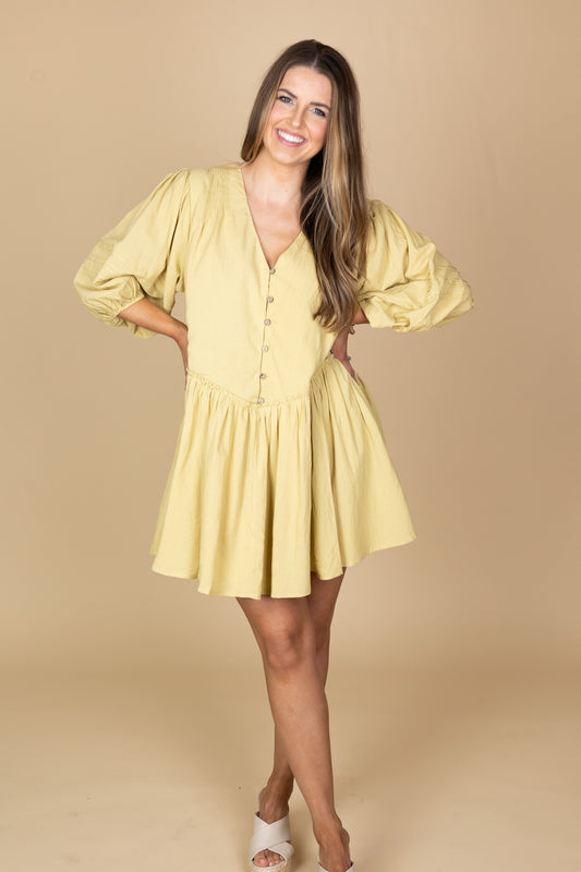 Kira Shift Dress in matcha green with flowy bodice, ruffle detailing, functional buttons, and three-quarter length sleeves