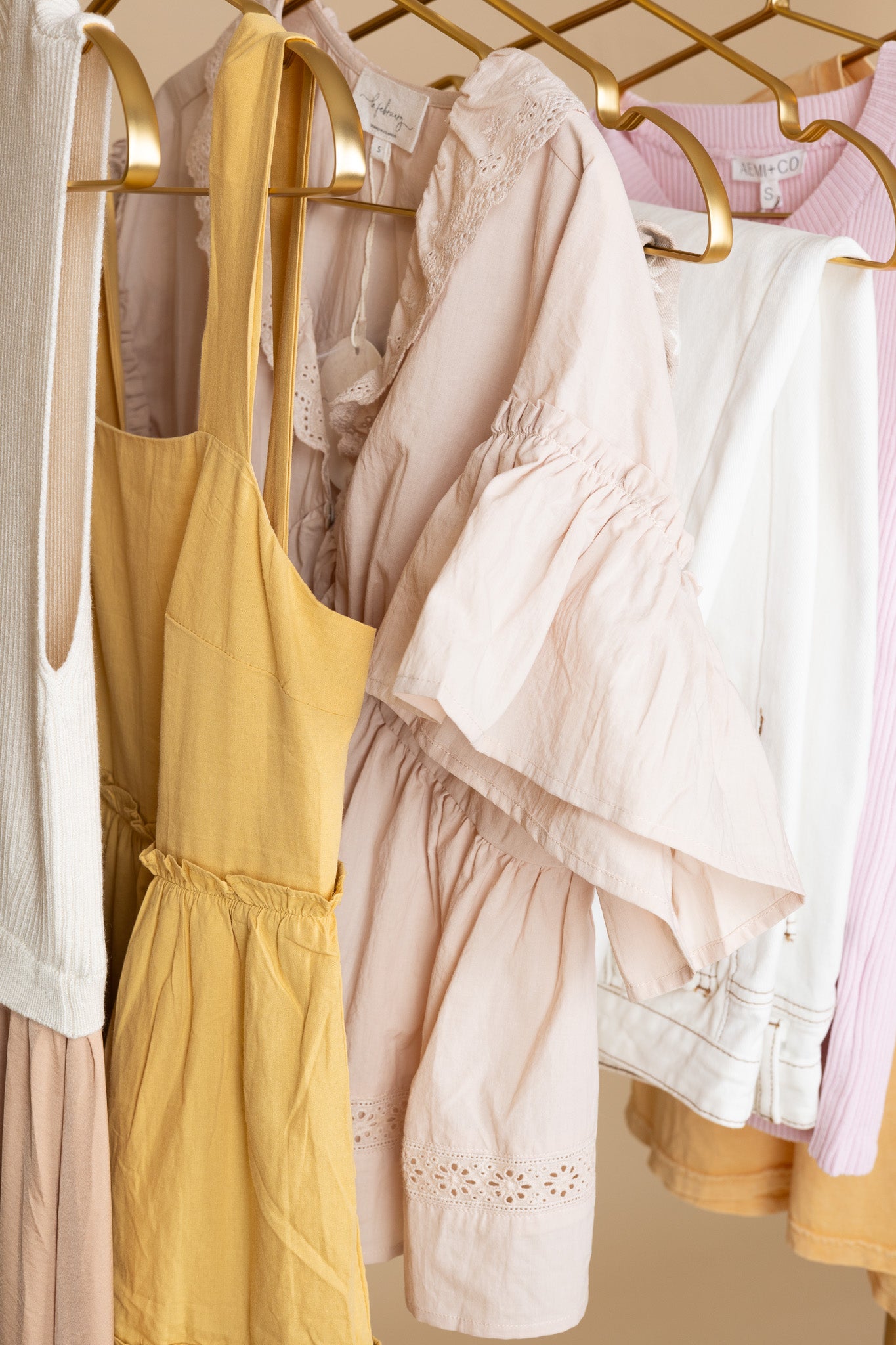 hanging Evie Eyelet Blouse in apricot with eyelet and ruffle detailing and shimmering functional buttons, nursing-friendly design