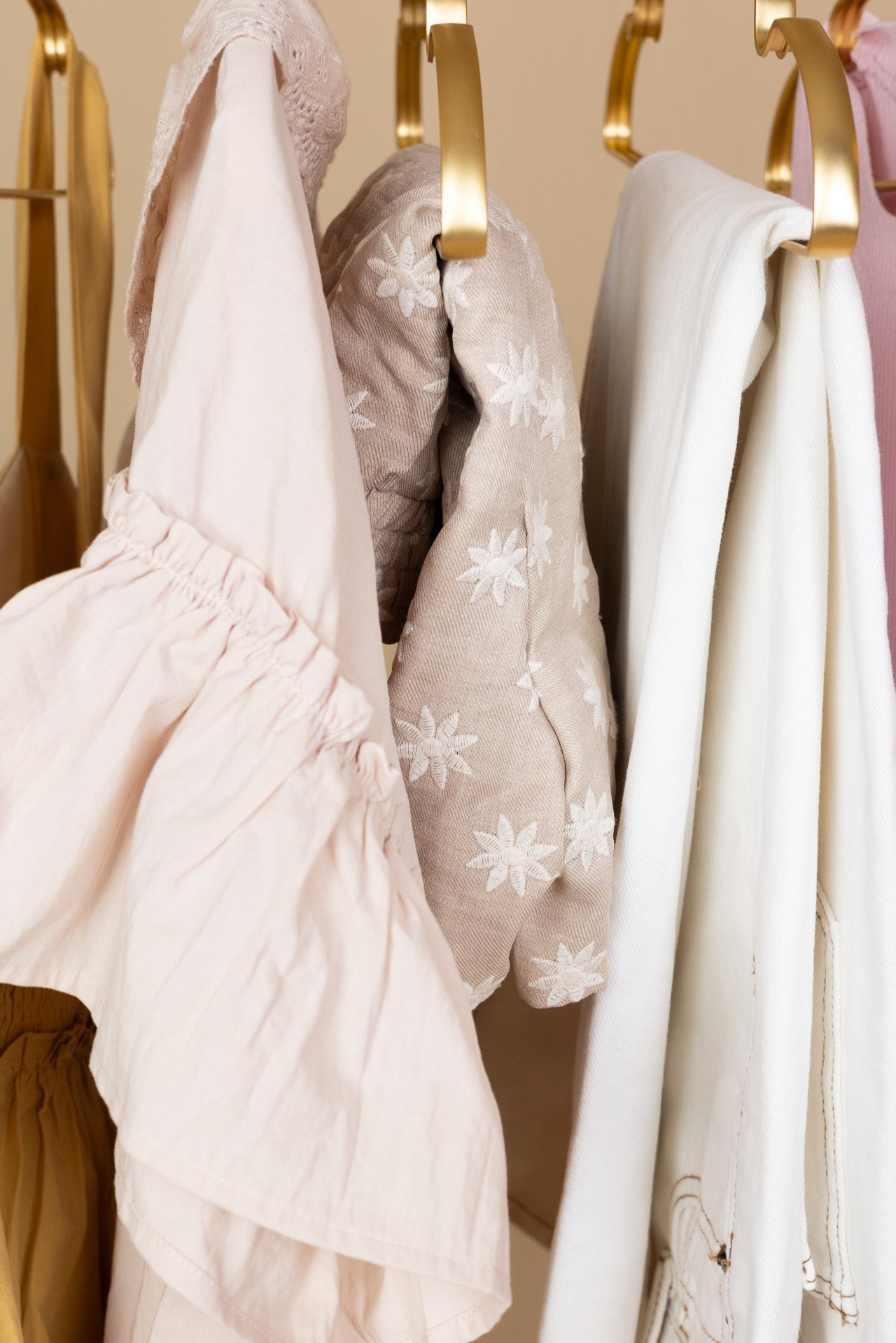hanging Hailey Floral Shorts in taupe with cream floral detailing, linen-like material, elastic waistband, functional pockets, and double lining