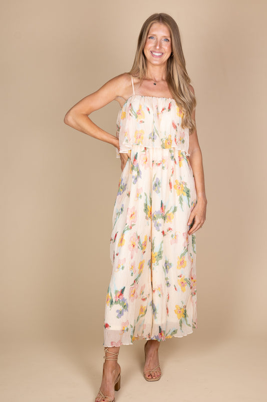 Megan Floral Jumpsuit in light pink chiffon with pleated floral detailing, ruffle top, adjustable straps, and wide-leg fit