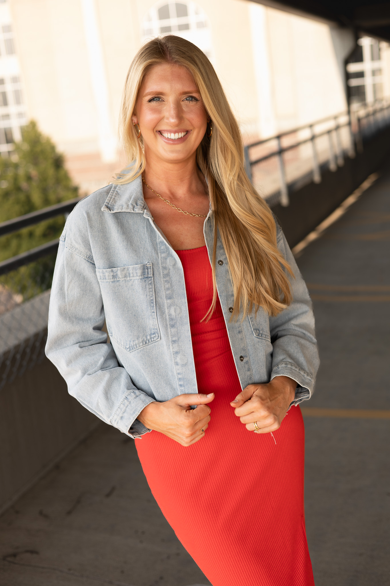 front view of fitted ribbed midi dress featuring side slit paired with cropped jean jacket, back has subtle open back with tie detail