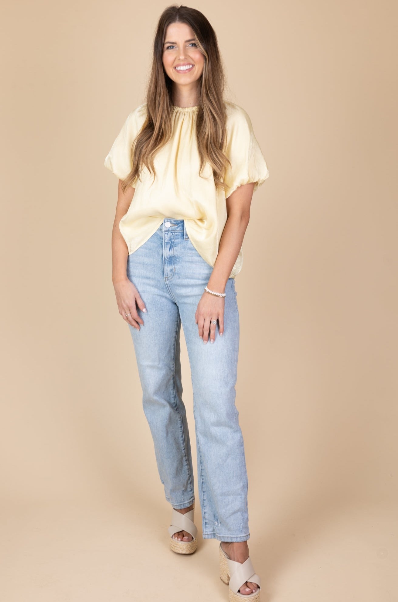 Zoomed out view of Light yellow blouse with subtle shimmer, puff sleeves, tie neck back, and double lining.