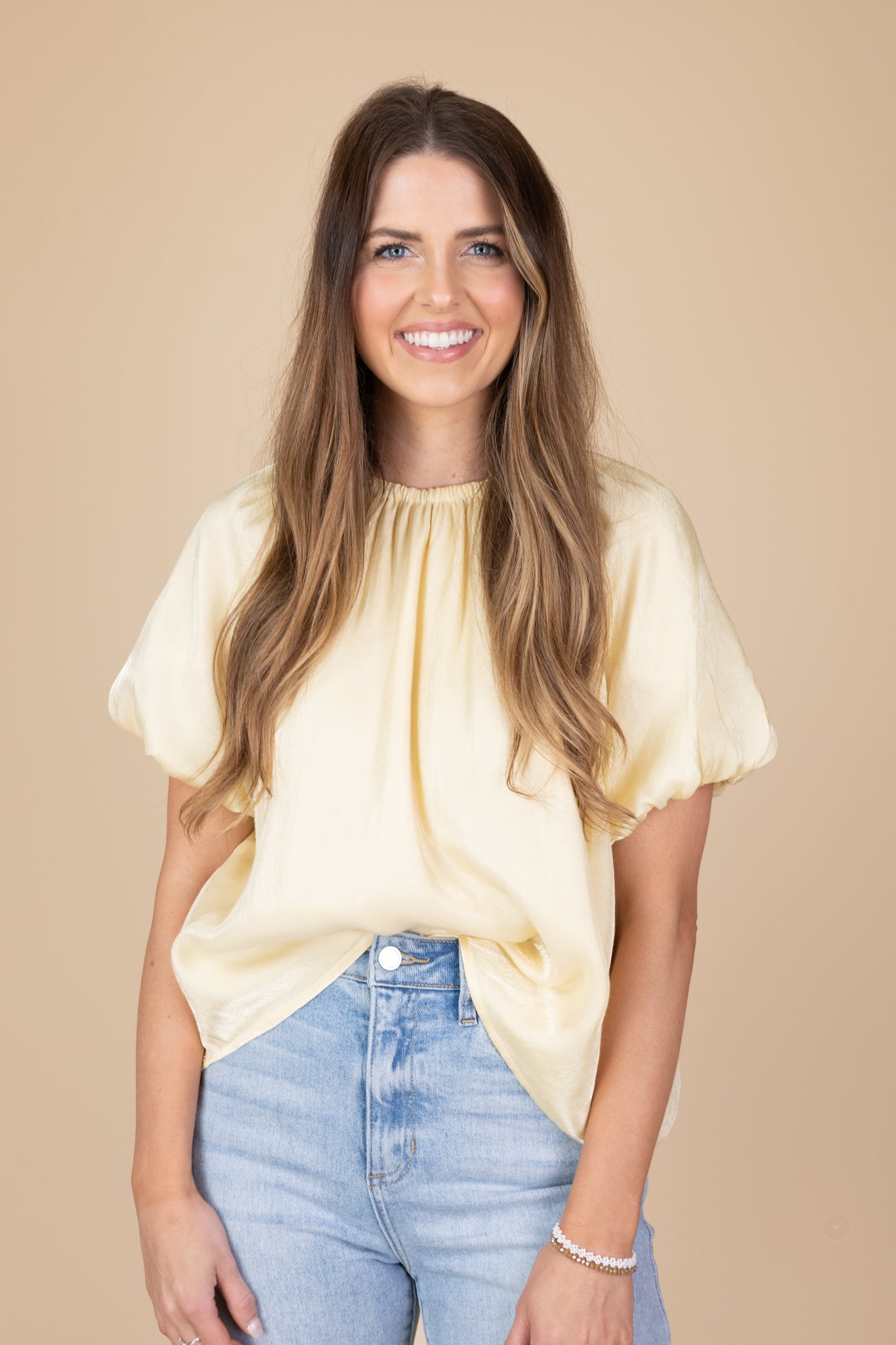 styled view of Light yellow blouse with subtle shimmer, puff sleeves, tie neck back, and double lining.