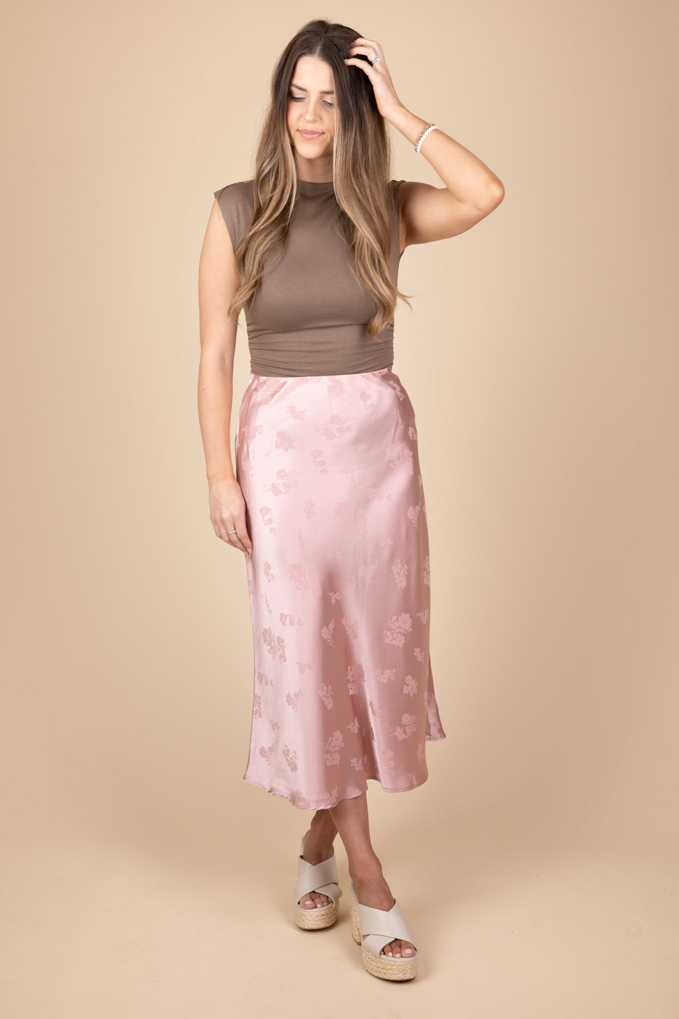 Styled view of Sienna satin floral midi skirt in mauve with subtle floral detailing, midi length, and elastic waistband. Exudes charm and sophistication.