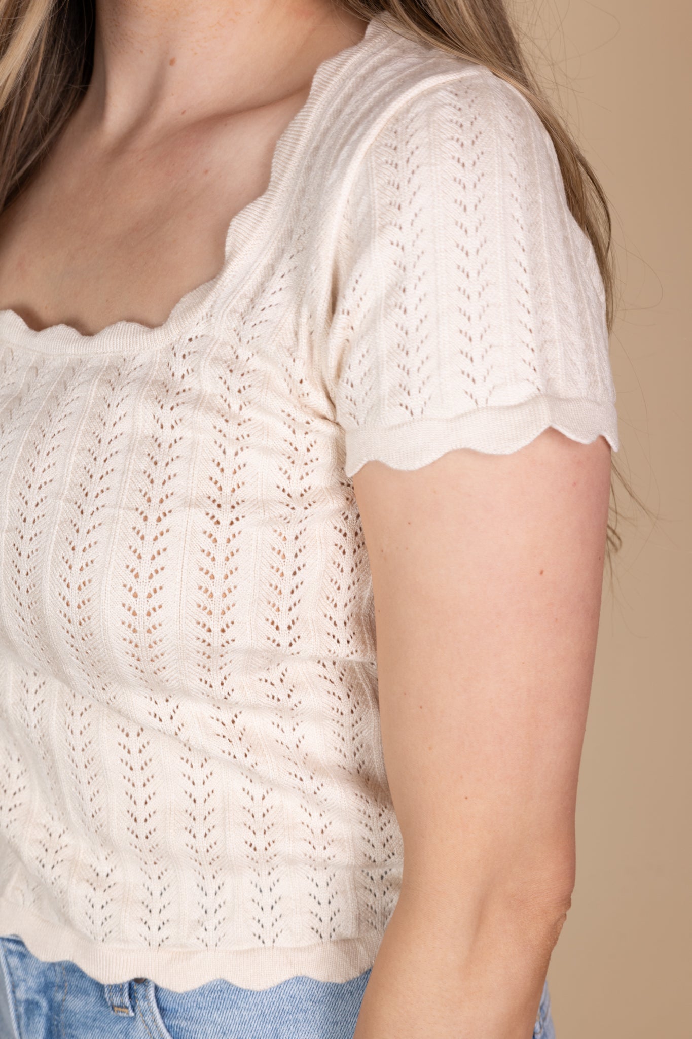 Close up detail view of Remi Scalloped Knit Top in cream with a square neckline, scalloped trim, and fitted design. Ideal for adding a feminine touch to your look.