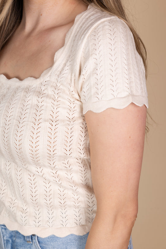 Close up detail view of Remi Scalloped Knit Top in cream with a square neckline, scalloped trim, and fitted design. Ideal for adding a feminine touch to your look.