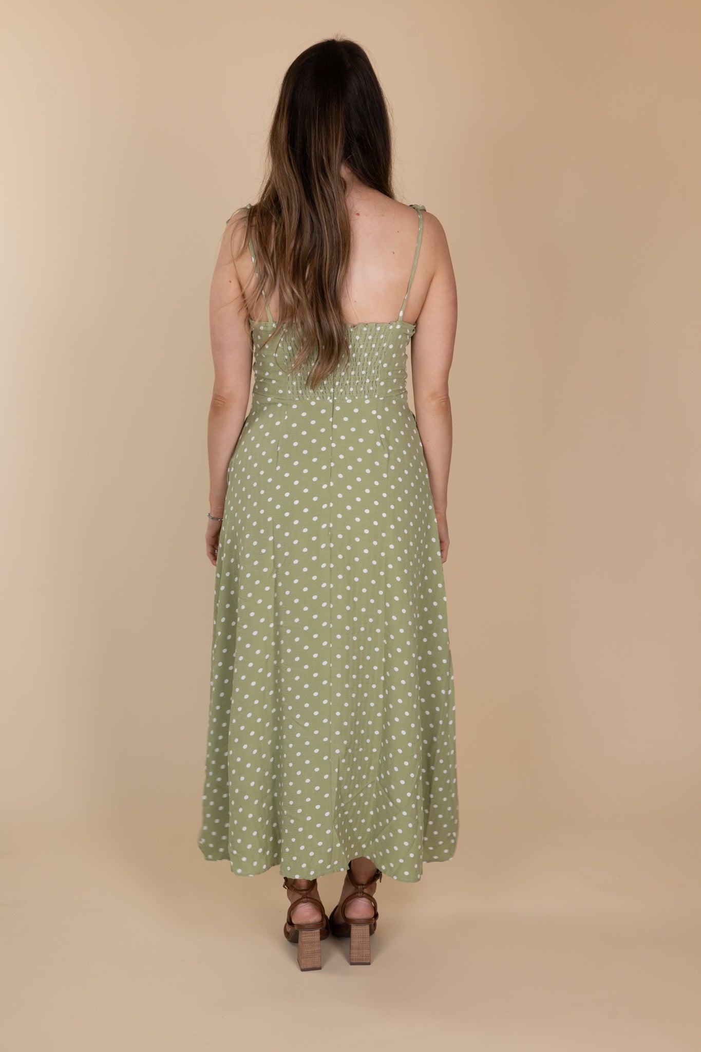 back view of Willow Classic Polka Midi Dress in light green with white polka dots, tie adjustable straps, fitted chest/torso, loose skirt, and midi length. True to size fit.