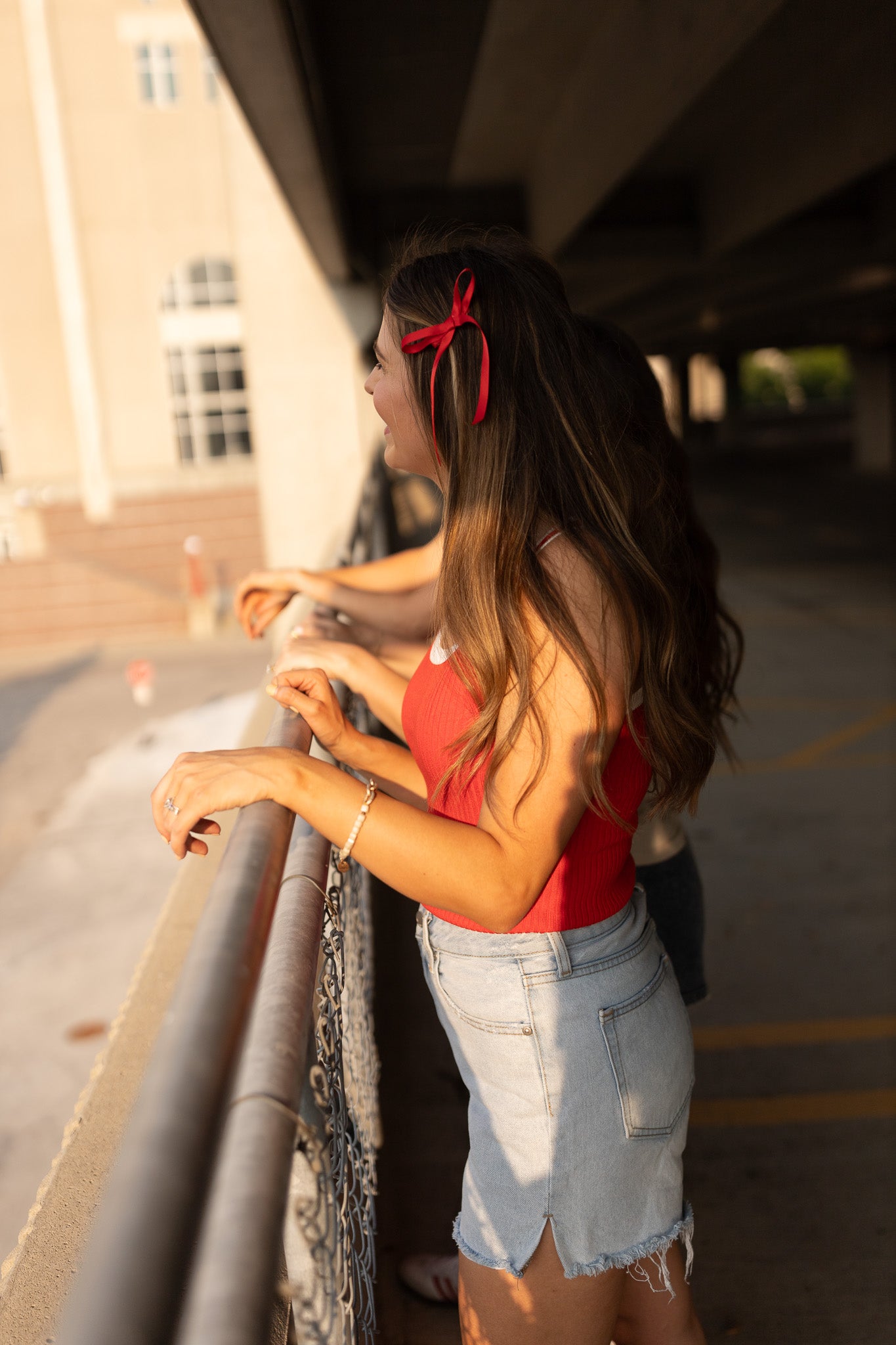 side view of red ribbed tank with white trim paired with light wash jean shorts