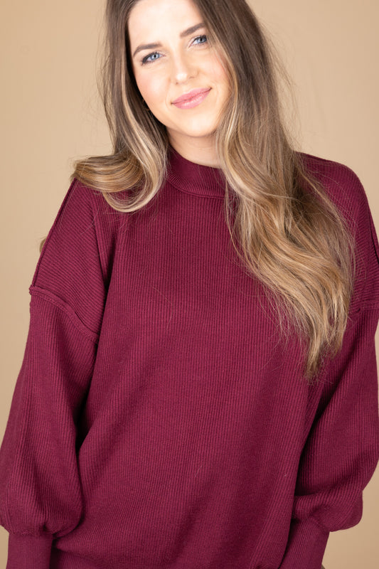 close up view of “Cozy Crewneck Sweater in Wine Red – a soft, oversized knit sweater with a classic crewneck design for effortless style.”

