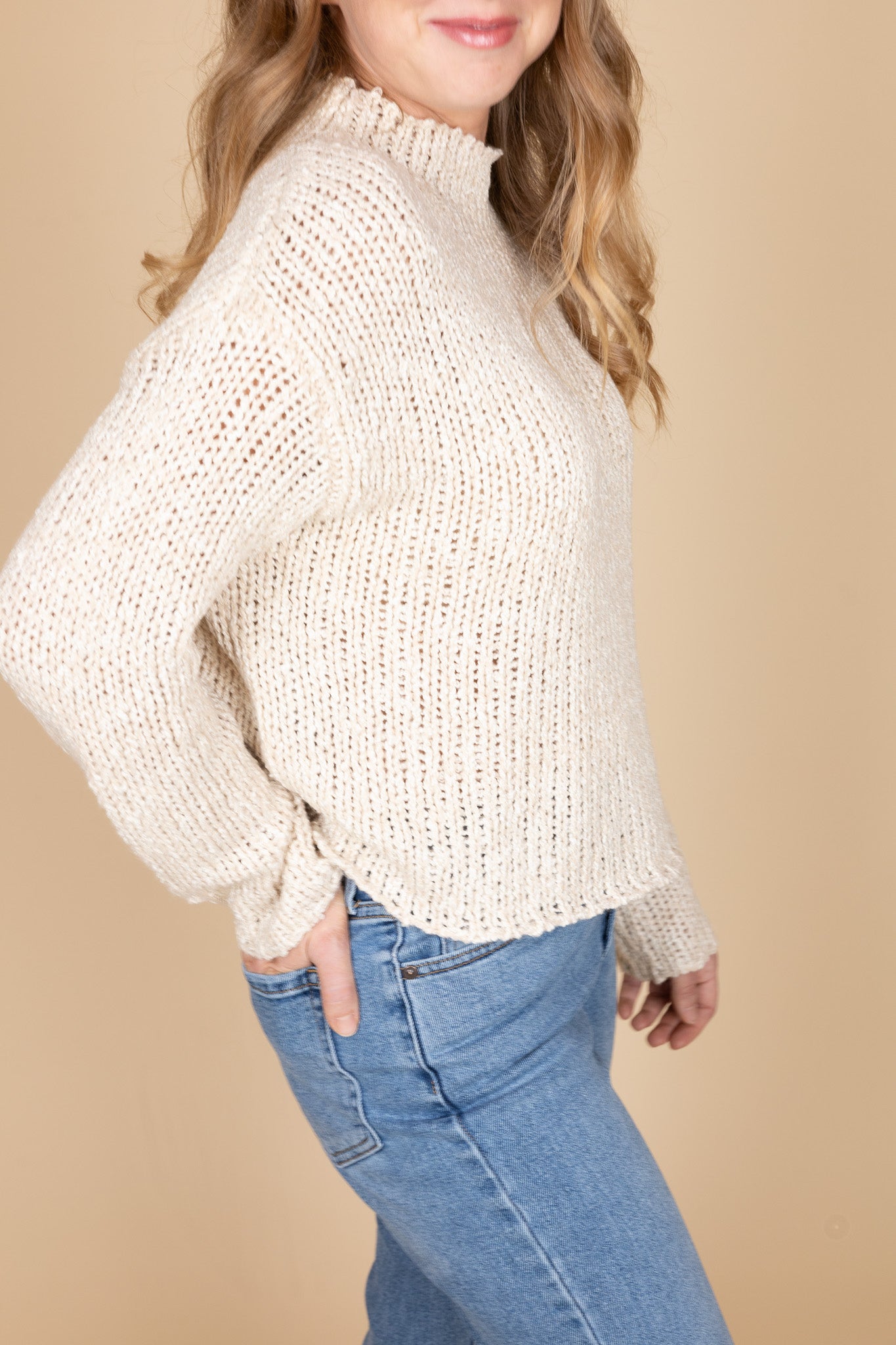 Crochet detailing and wide stitch pattern on oat-colored sweater — soft women’s knit fabric close-up
