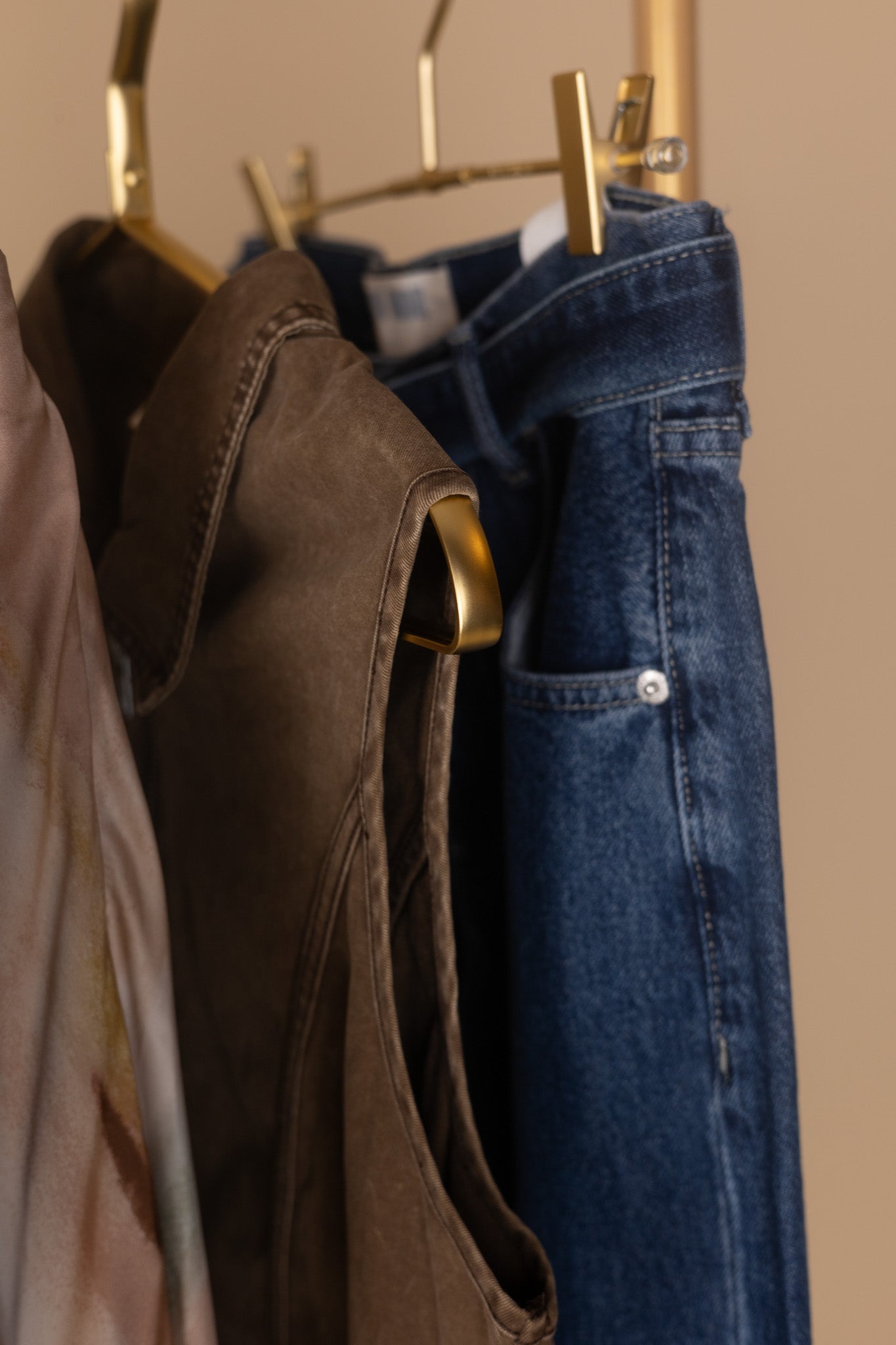 close detail of Front zipper and V-hem waist detail on women’s twill denim mini dress — structured fabric close-up